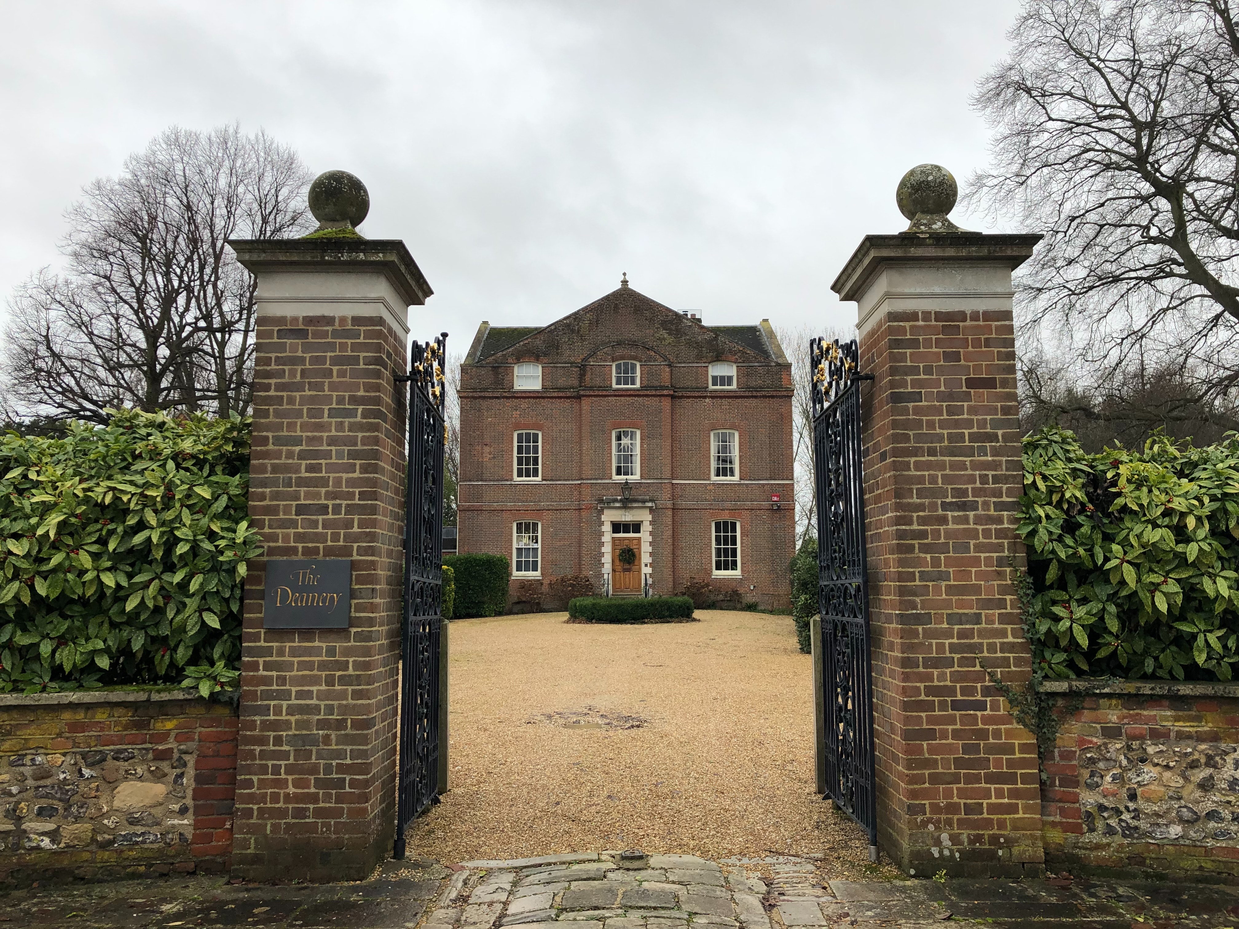 A large brick house with an open gate. 