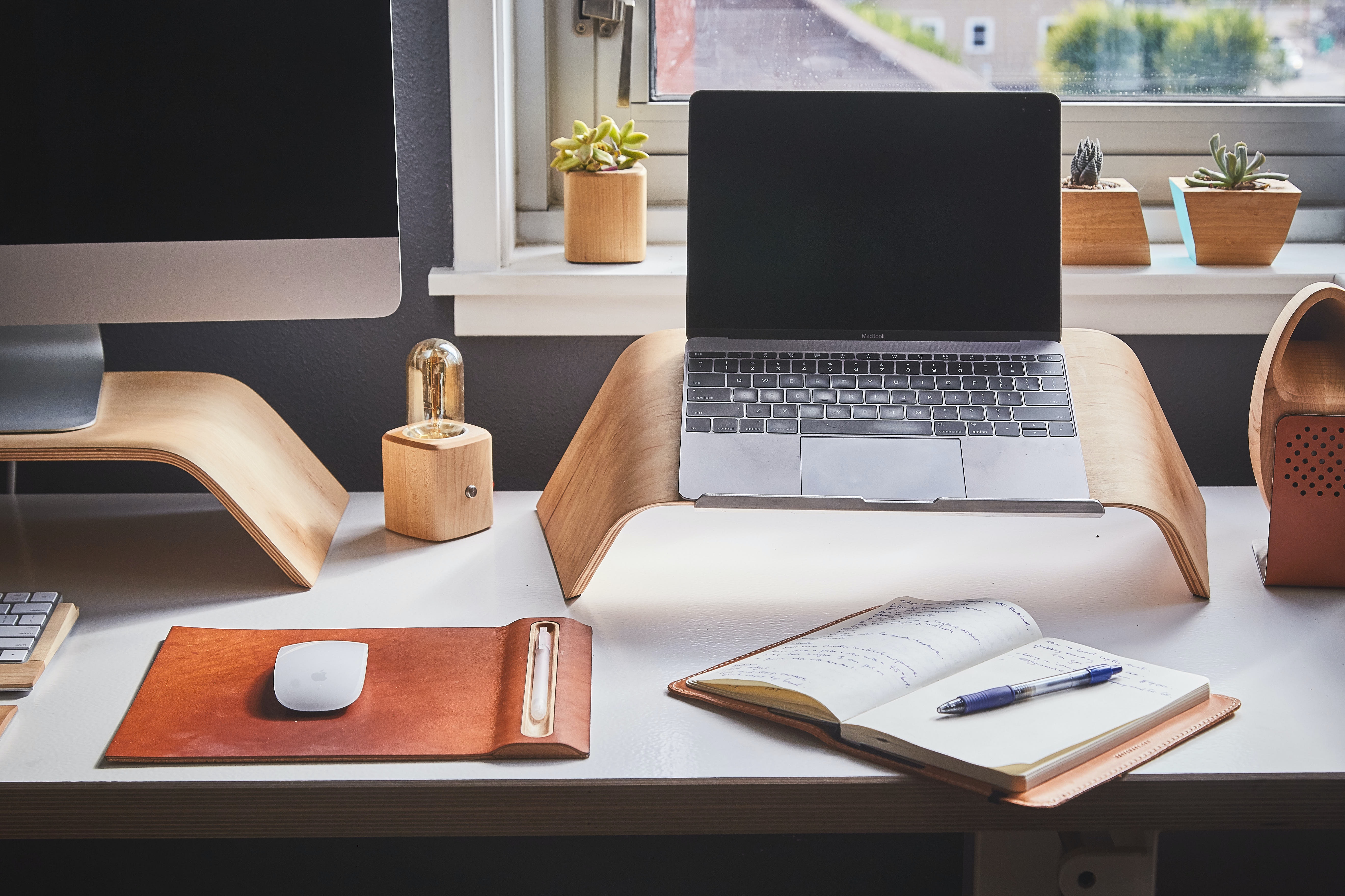 Laptop, computer and a notebook on a desk.  