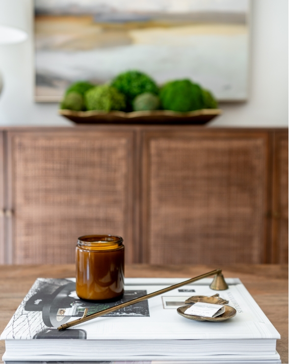 A book and candle on a coffee table.