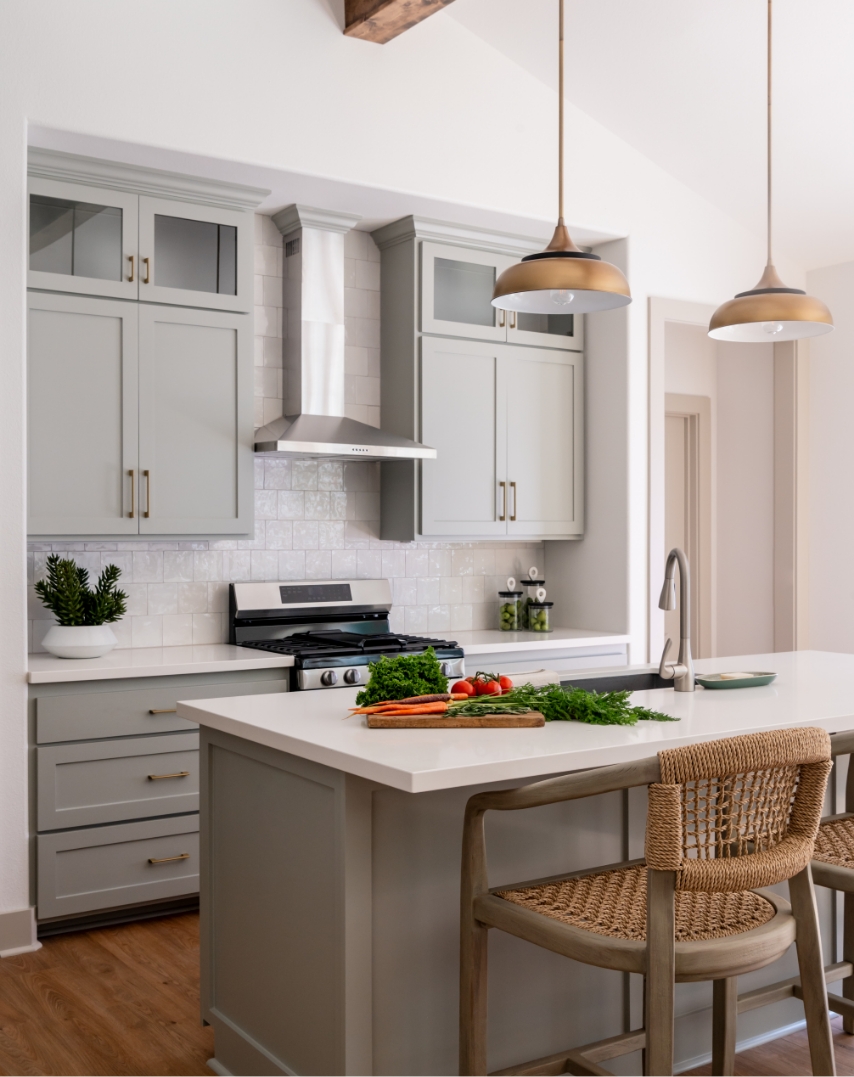 A modern kitchen with lights above a kitchen island.