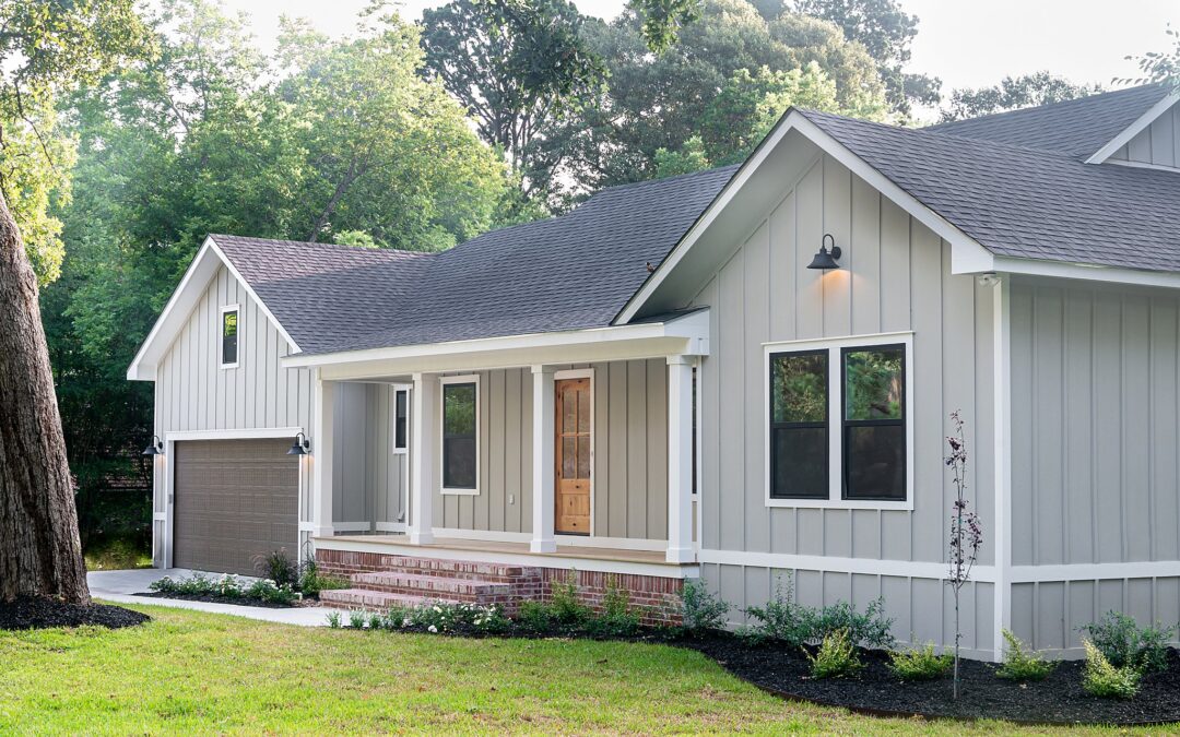 A grey house with brick stairs and a garage.