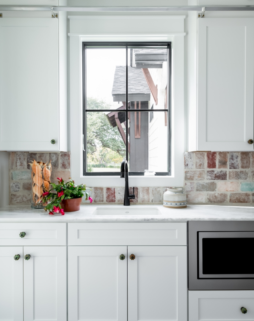 A modern kitchen with lights above a kitchen island.