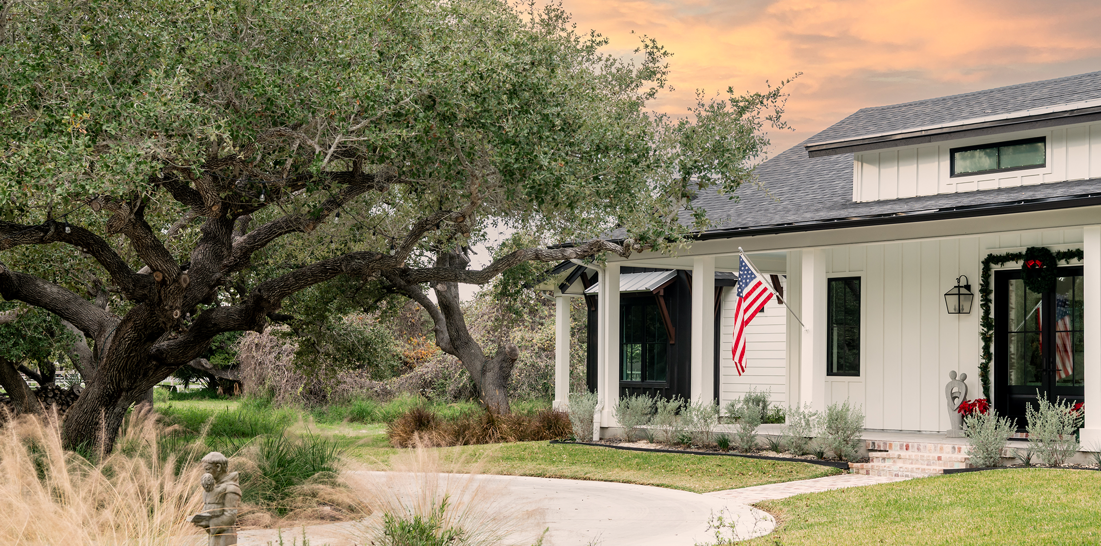 A custom-built home with a tree in the front yard.