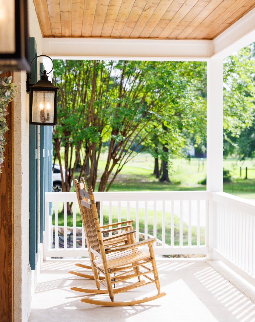 A couch with pillows and a kitchen with barstools